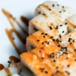 Hamachi collar recipe with soy sauce, sake, and mirin, served with sesame seeds and scallions
