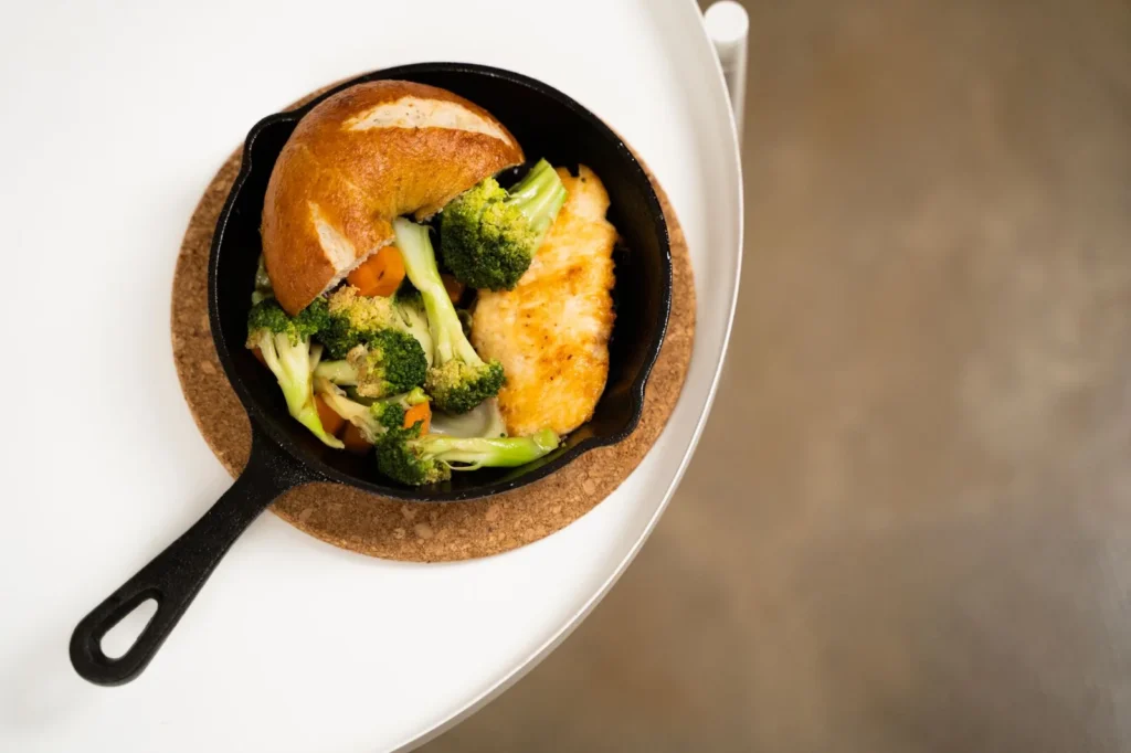 30 minute weeknight dinner ideas for families shown as a skillet of honey soy chicken noodles with broccoli and melted cheddar