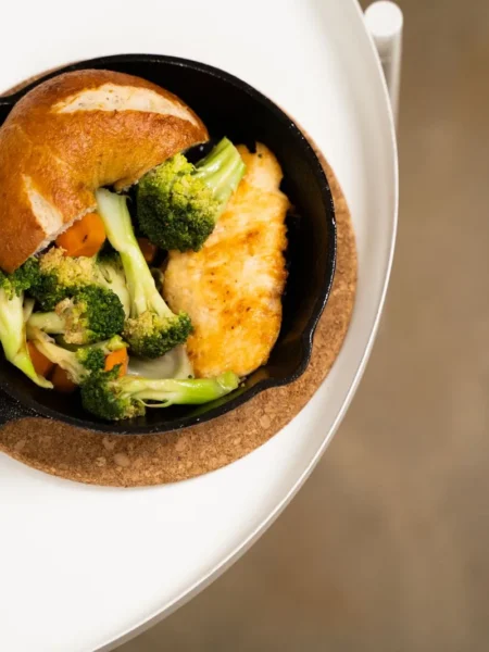 30 minute weeknight dinner ideas for families shown as a skillet of honey soy chicken noodles with broccoli and melted cheddar