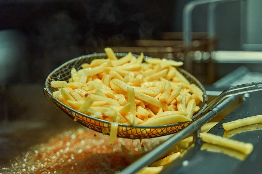 air fryer frozen seasoned fries in a basket, golden and crispy with parsley on top