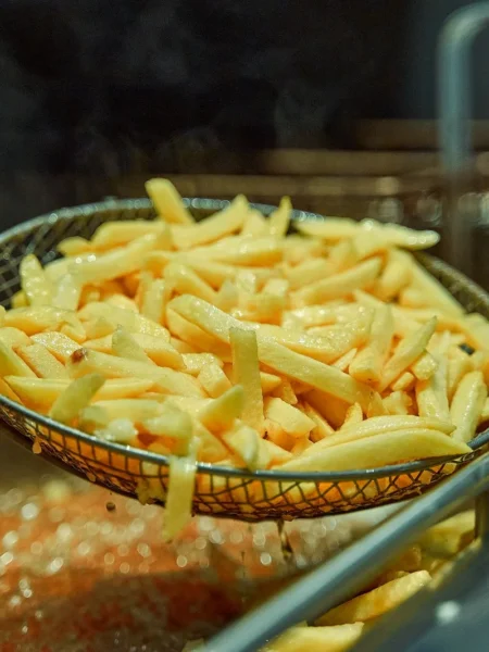 air fryer frozen seasoned fries in a basket, golden and crispy with parsley on top