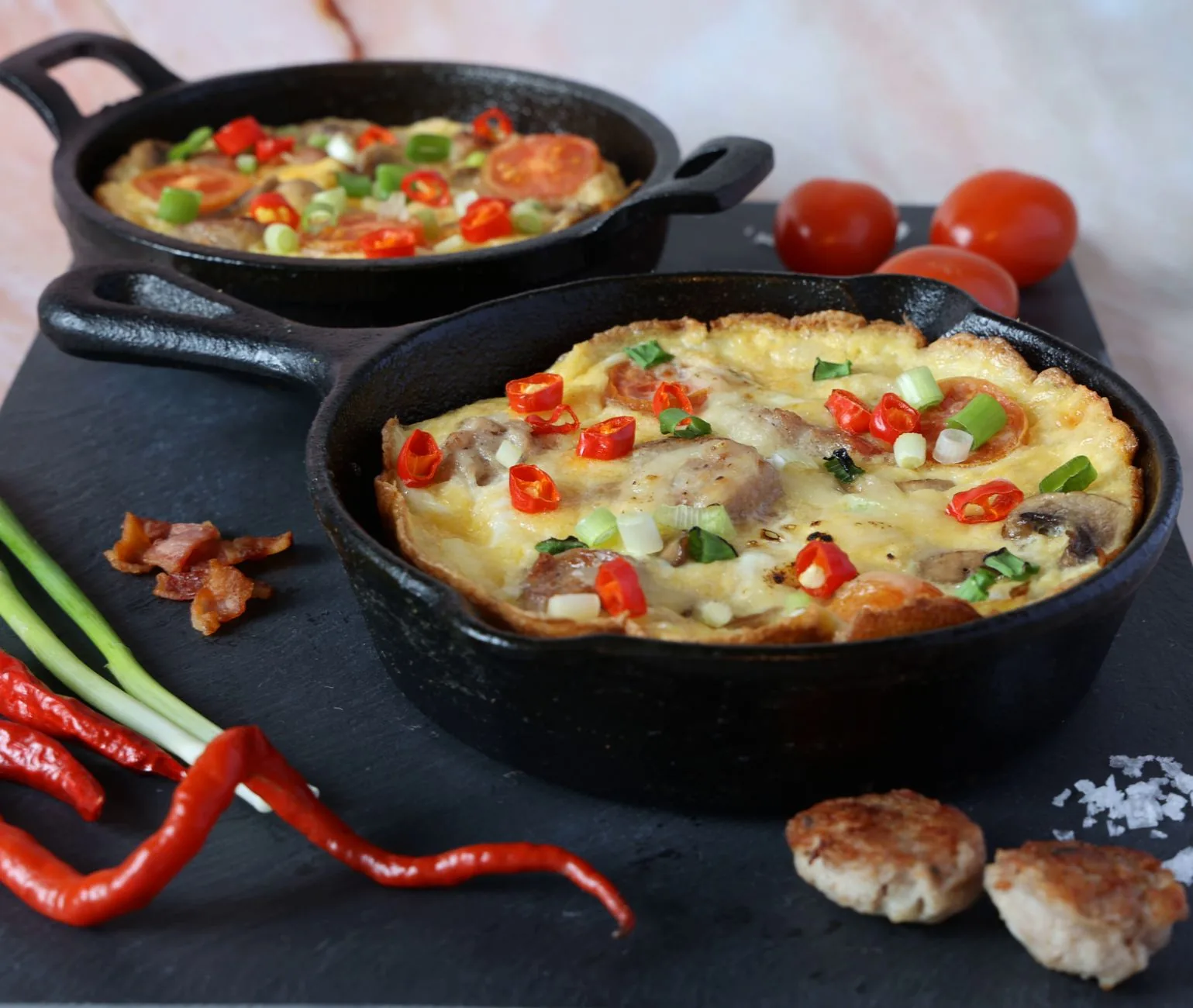 apple sausage and caramelized onion frittata in a skillet with apples and onions