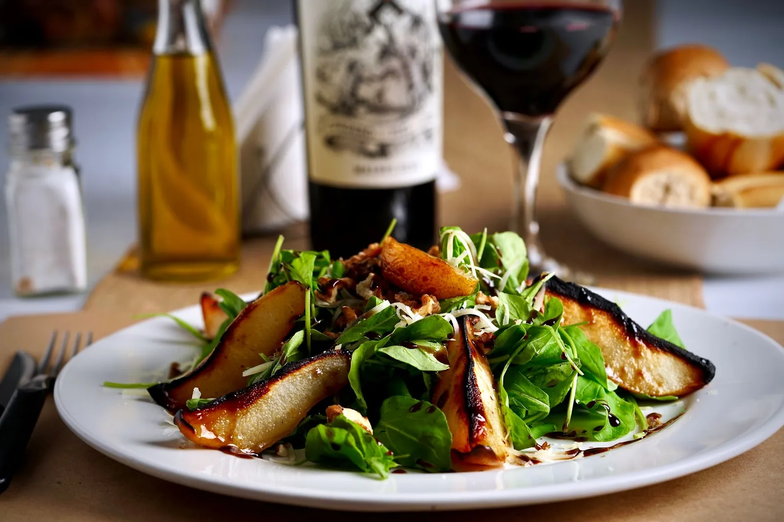 arugula pear salad with walnuts and parmesan on white platter