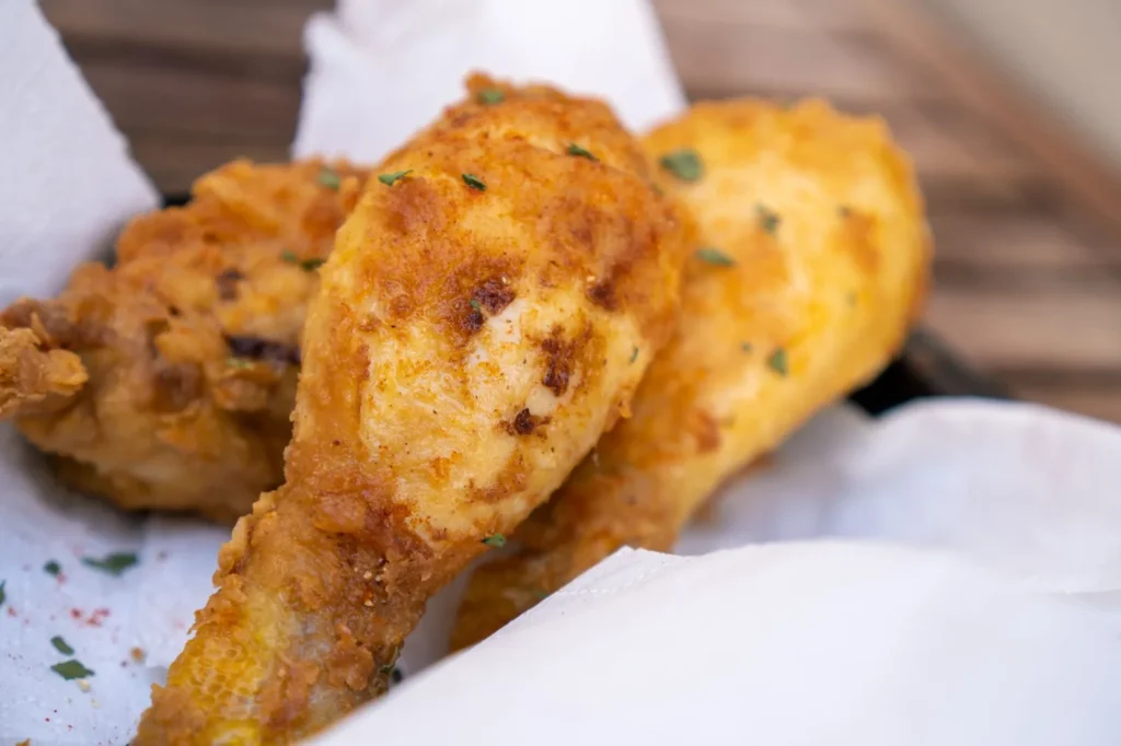 baked fried chicken pieces with golden cornflake crust and crisp edges on a sheet pan