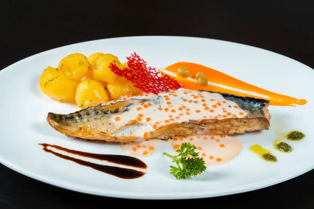 baked salmon recipe with lemon butter sauce showing flaky salmon fillets in a glossy lemon butter sauce with parsley in a white baking dish