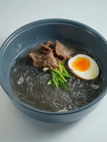 beef and noodles recipe for comfort dinner with seared sirloin strips, wide egg noodles, and thick onion broth in a pot
