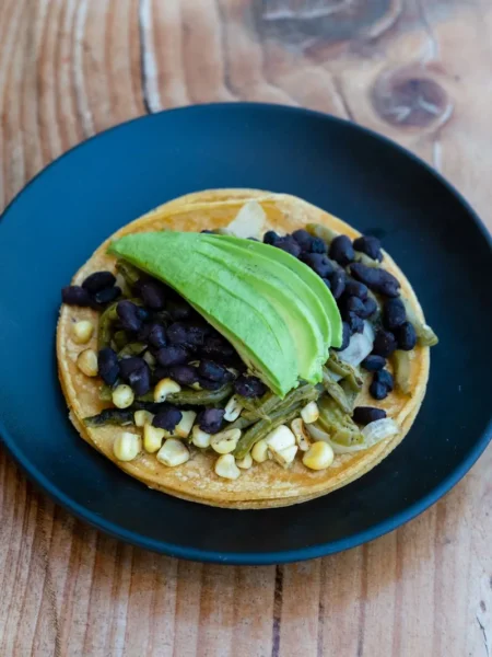 black bean salsa recipe in a white bowl with black beans, yellow corn, red pepper, and green cilantro