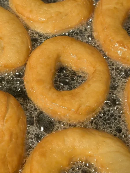 buttermilk donuts recipe showing golden fried donuts with a smooth white vanilla glaze on a wire rack