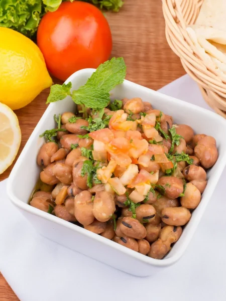 cannellini bean salad recipe with creamy white beans, cherry tomatoes, cucumber, and red onion in lemon dressing on a white plate