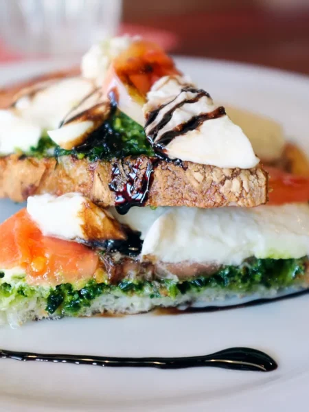 caprese bruschetta recipe with toasted baguette, diced mozzarella, Roma tomato, and basil drizzled with olive oil