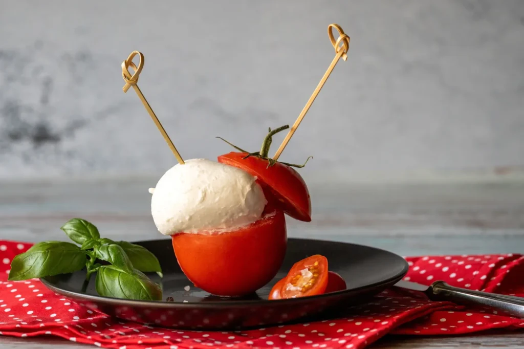 caprese skewers recipe for appetizers with cherry tomato halves, fresh mozzarella balls, and basil on wooden sticks