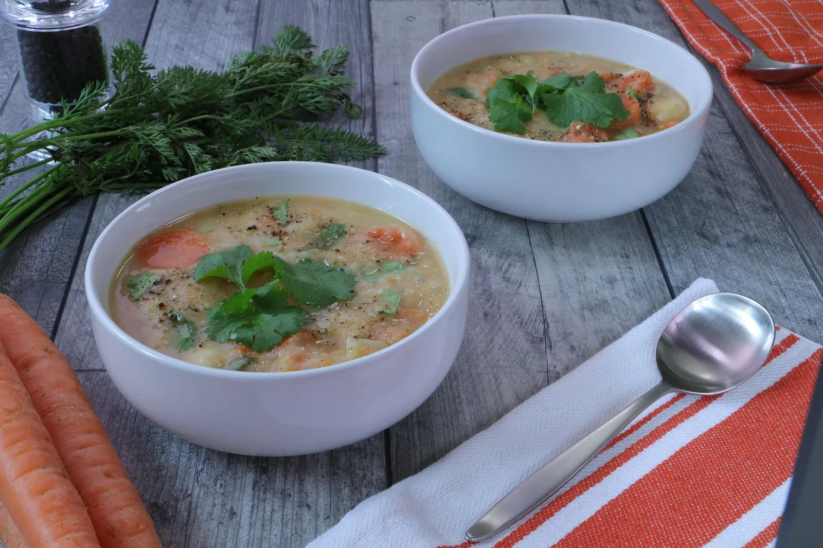 bowl of carrot soup with ginger and lemon slice