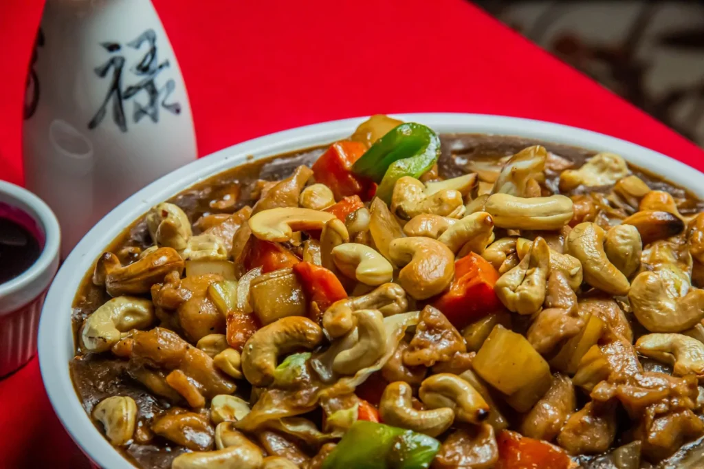 cashew chicken stir fry with golden chicken pieces, toasted cashews, and bright broccoli in a glossy sauce in a skillet