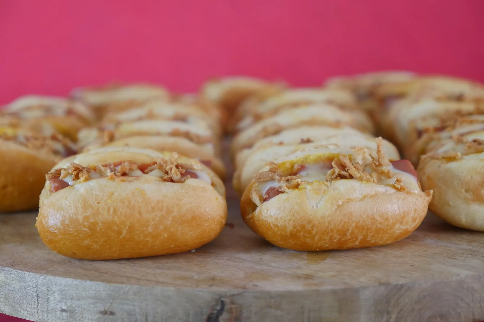 tray of cheese and onion sausage rolls with golden pastry