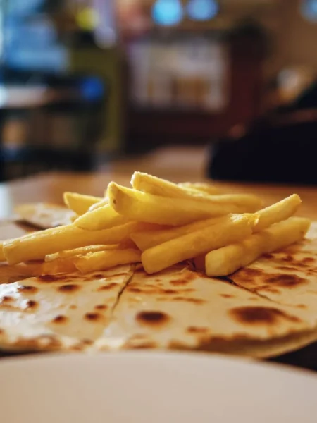 cheese quesadilla recipe with golden toasted flour tortillas and melted cheddar pulled into strings on a wooden board