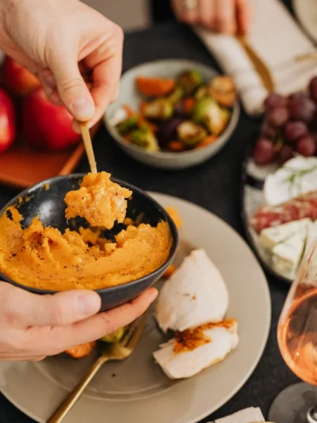 cheesy mashed potatoes in a white bowl with melted sharp cheddar and steam rising from the creamy surface
