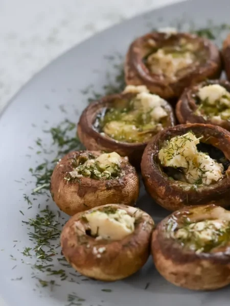 cheesy old bay crab stuffed mushrooms with lump crab, melted cheddar, and golden baked button caps on a tray