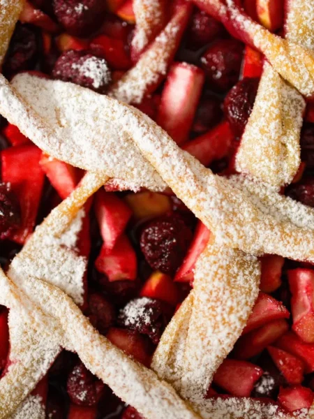 cherry pie bombs recipe with golden flaky biscuit pockets filled with tart cherry filling and coarse sugar topping on a parchment tray