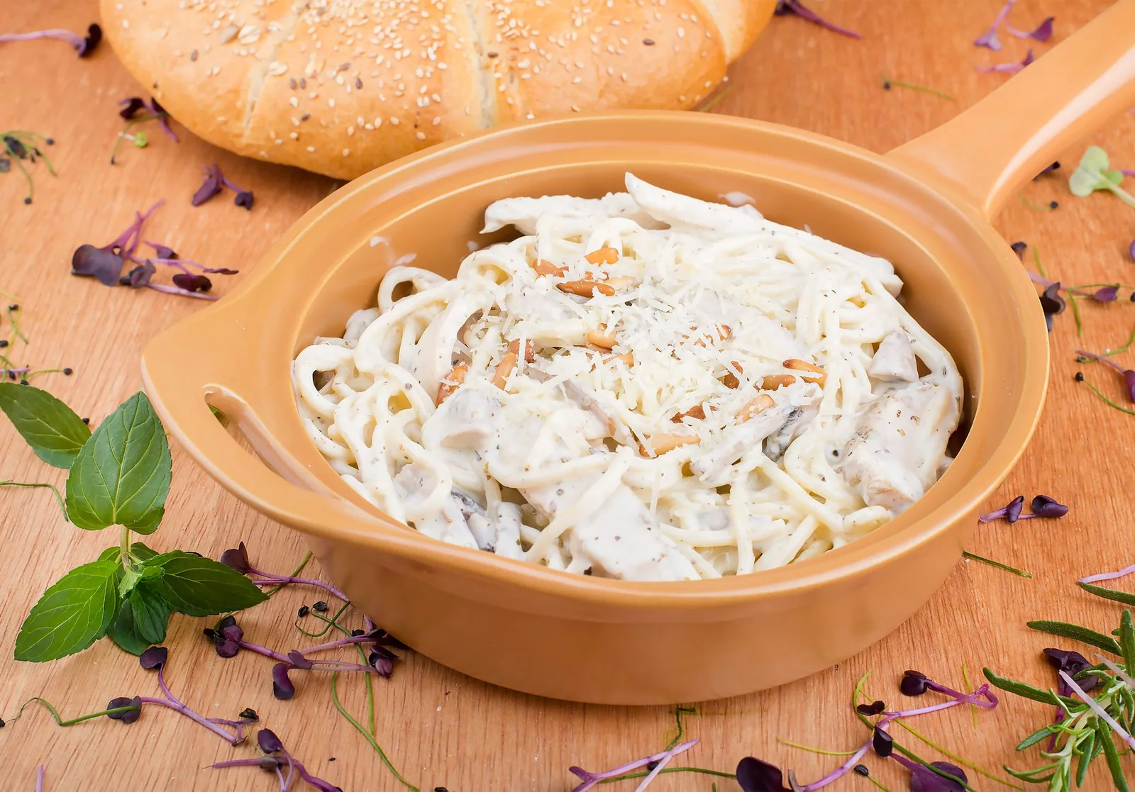 skillet of chicken alfredo with fettuccine and parsley