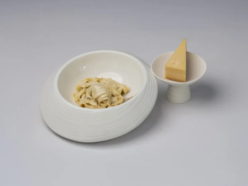 chicken alfredo recipe with seared chicken strips and fettuccine in a glossy parmesan cream sauce on a white plate