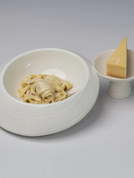 chicken alfredo recipe with seared chicken strips and fettuccine in a glossy parmesan cream sauce on a white plate