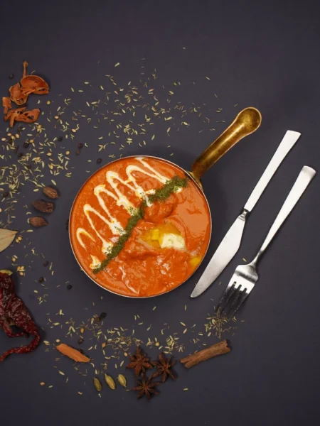 chicken and aubergine curry in a dark pan with tender chicken chunks and soft aubergine cubes in spiced tomato gravy