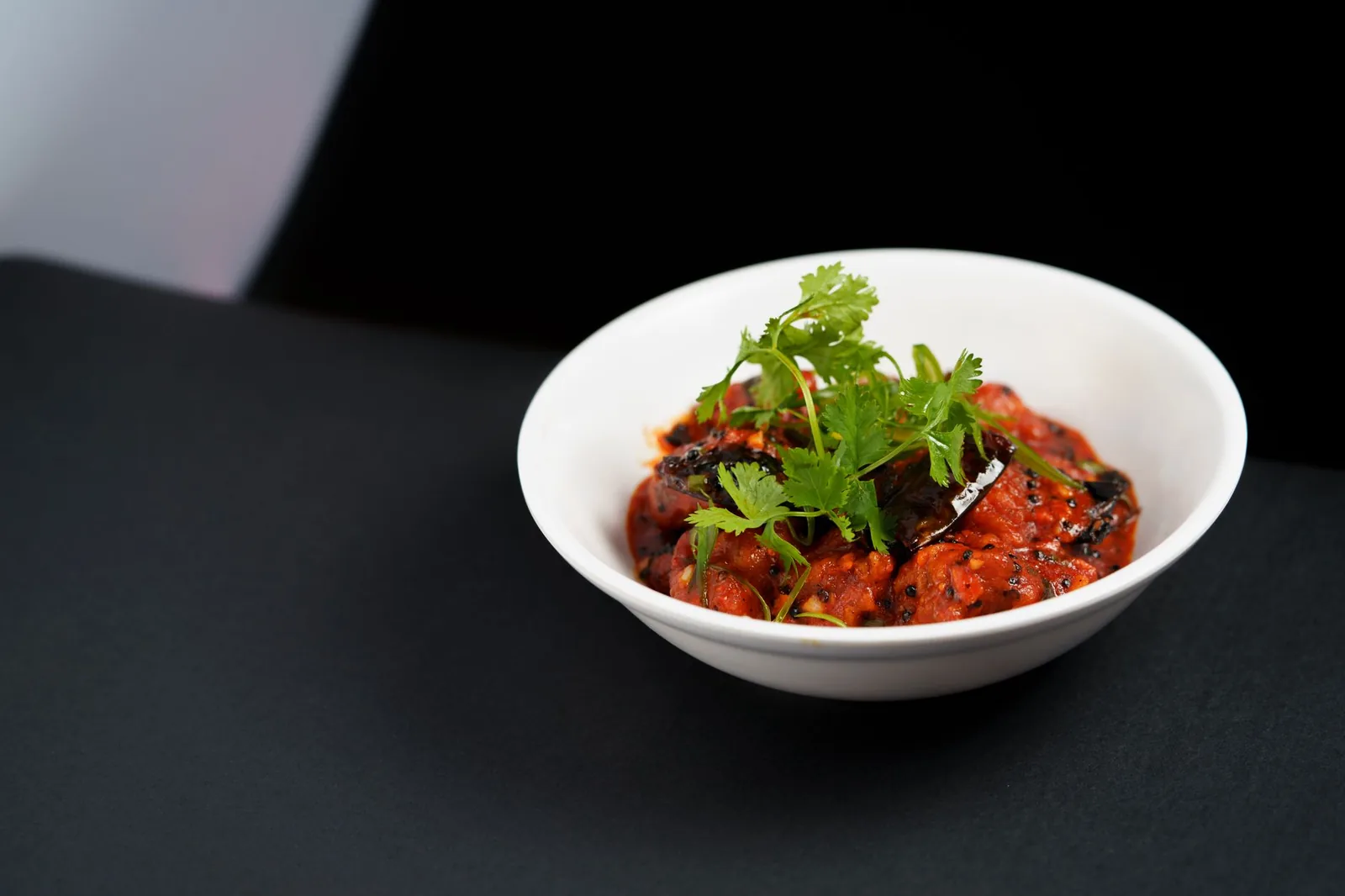 chicken and aubergine curry in pan with tomato gravy