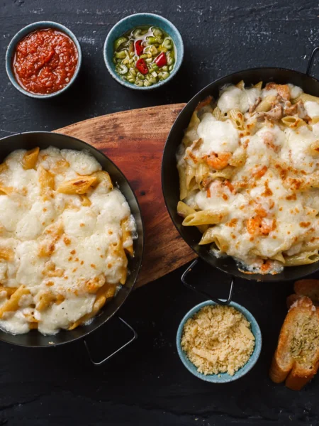 chicken and leek pasta bake in a white dish with golden cheddar top, soft leeks, and penne in creamy sauce