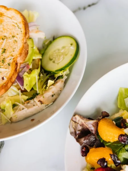 chicken salad sandwich recipe with grapes on toasted roll with creamy filling, red grape halves, and toasted almonds