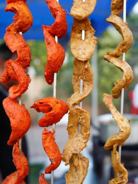 chicken tikka kebab with charred red onion and green pepper on a white plate
