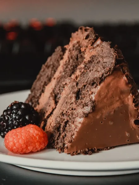 chocolate ganache banana cake recipe with glossy dark topping and moist cocoa crumb on a round plate