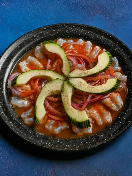 citrus ceviche recipe with white fish cubes, cucumber, red onion, and avocado in lime lemon orange juice