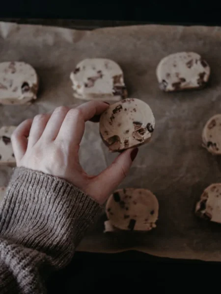 cookie dough frozen yogurt bites with chocolate chip centers and a glossy white yogurt shell on a tray