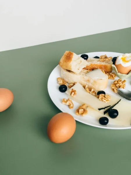 cottage cheese breakfast bowl high protein with a soft fried egg, blueberries, walnuts, and chia seeds in a white shallow bowl