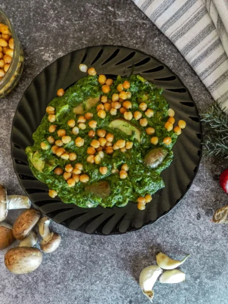 creamy chickpea stew in a pot with tender chickpeas, wilted spinach, and coconut milk broth