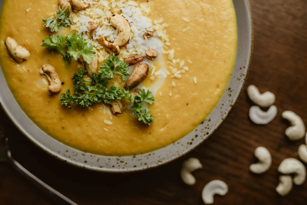 creamy dairy free white chicken chili in a bowl with white beans, chicken, and cilantro on top