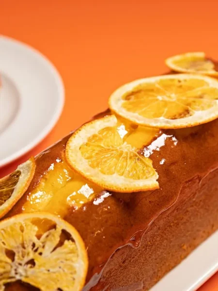 creme fraiche pound cake sliced on a white plate showing a moist golden crumb with lemon zest specks