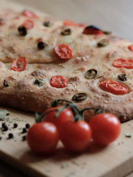 easy baked halibut with tomatoes showing flaky white fish fillets over roasted cherry tomatoes and olives in a baking dish