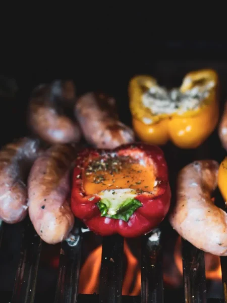 easy italian sausage and vegetable sheet pan dinner with browned sausage links, bell peppers, zucchini, and red onion on a rimmed pan