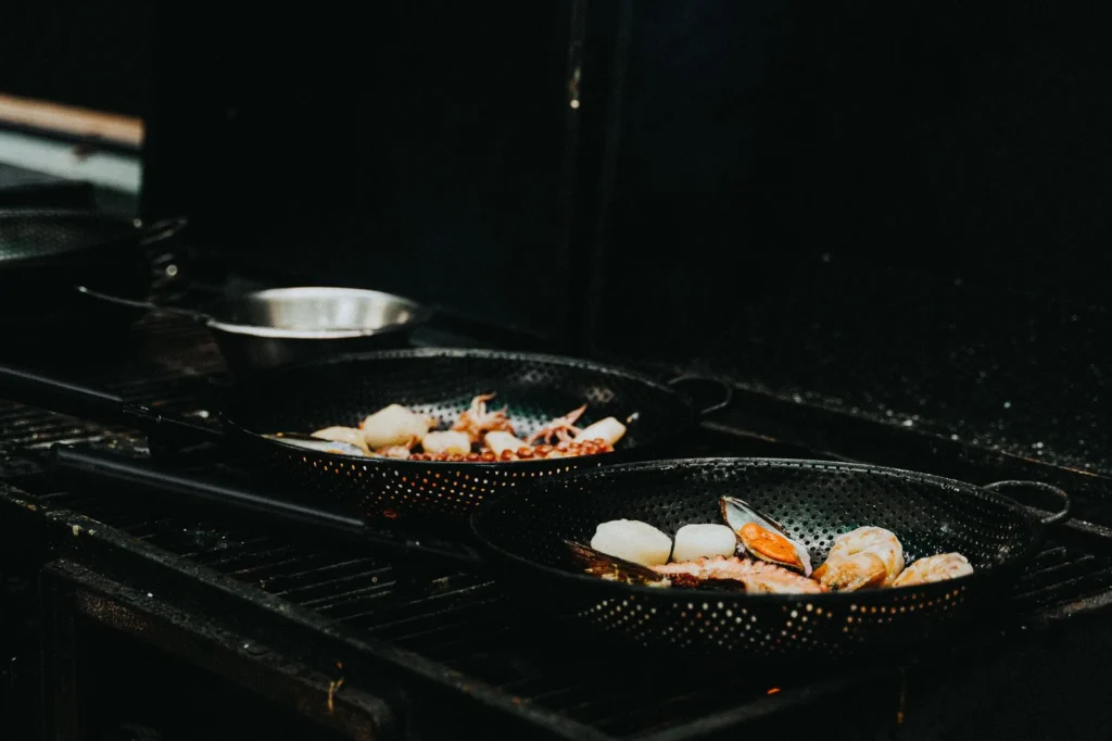 garlic butter mussels recipe in a cast iron skillet with open shells, cherry tomatoes, and parsley in white wine broth