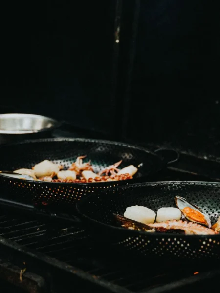 garlic butter mussels recipe in a cast iron skillet with open shells, cherry tomatoes, and parsley in white wine broth