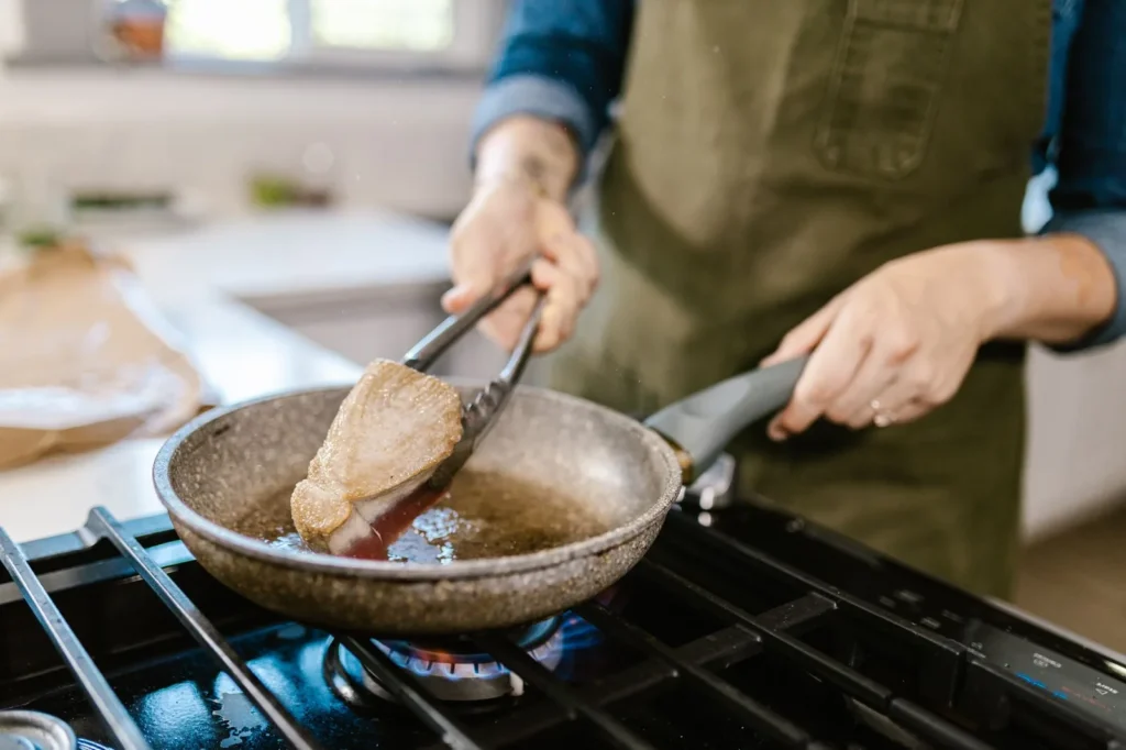 geoduck steak recipe with golden pan-seared clam steaks, butter glaze, and parsley on a wooden board