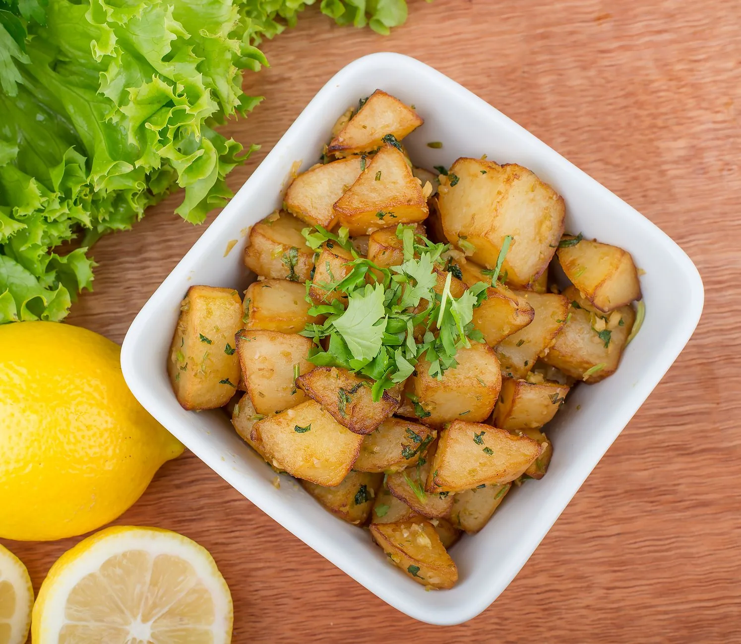 roasted greek lemon potatoes with oregano and parsley on sheet pan