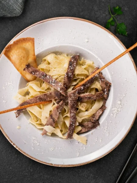 ground beef stroganoff recipe for busy nights with creamy mushroom gravy and wide egg noodles in a skillet