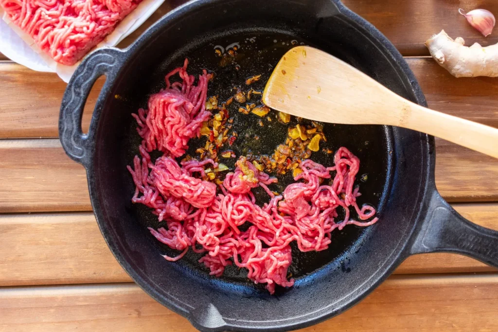 ground turkey skillet recipe for dinner with browned turkey, red pepper, black beans, and melted cheddar in a pan