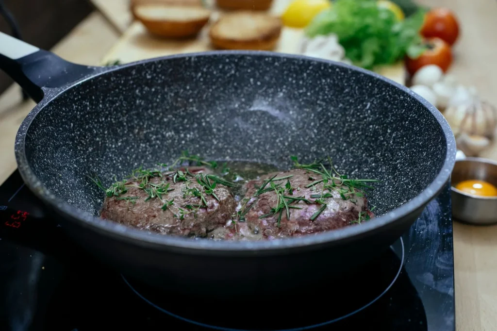 how to make burgers on the stove with juicy beef patties, melted cheddar, and toasted buns in a cast-iron skillet