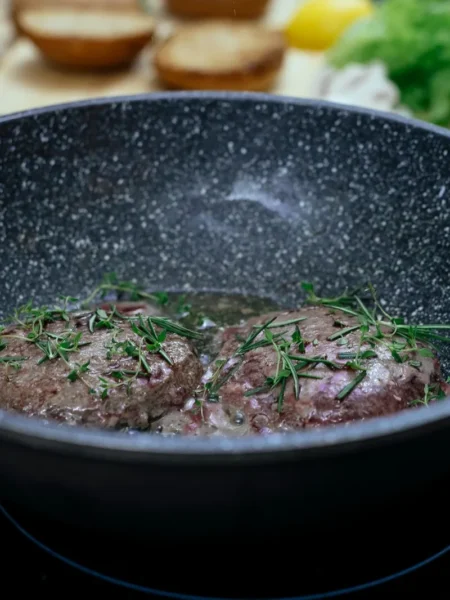 how to make burgers on the stove with juicy beef patties, melted cheddar, and toasted buns in a cast-iron skillet