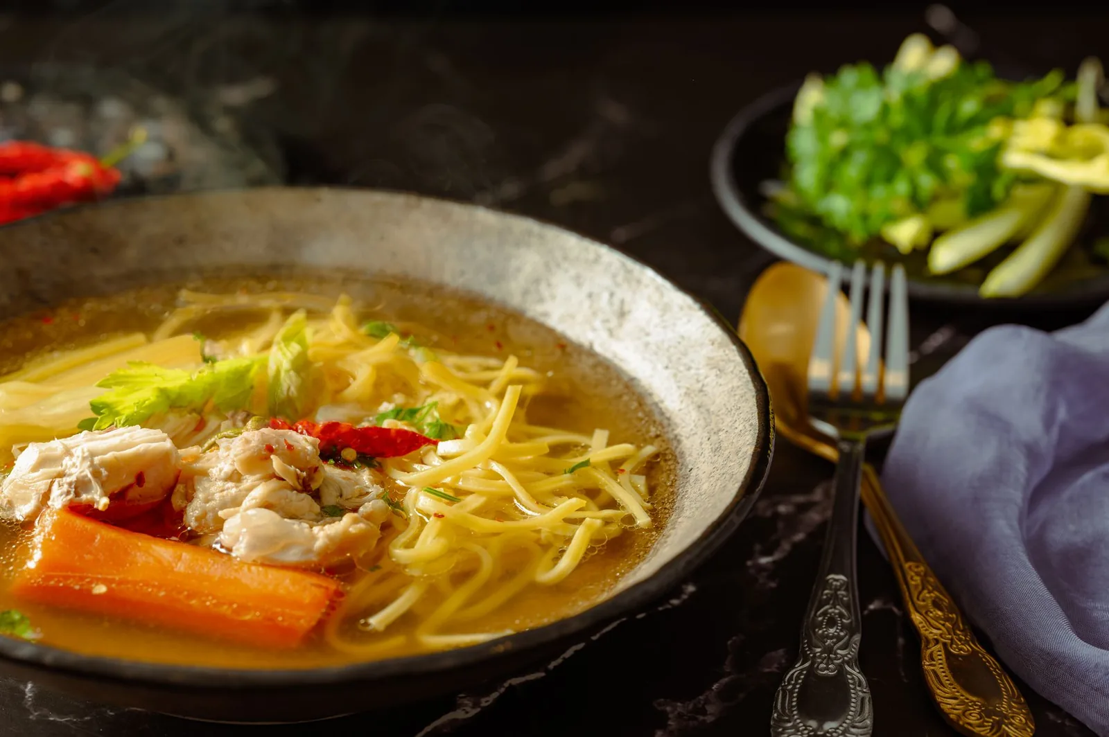 bowl of chicken noodle soup with noodles and carrots