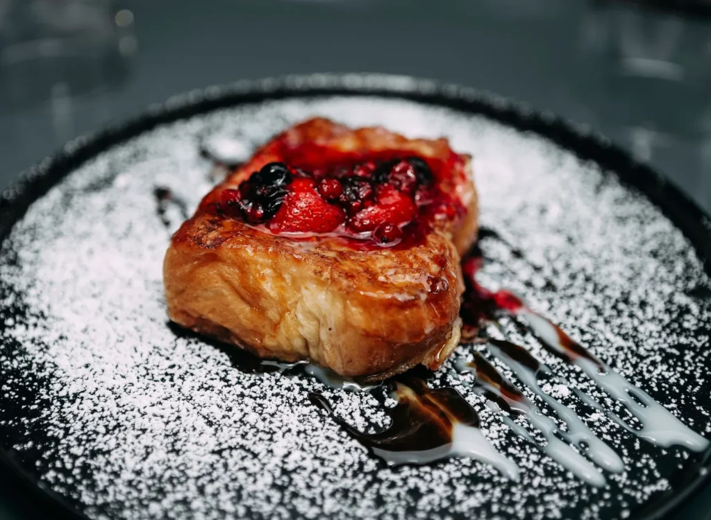 instant pot french toast casserole recipe with cubed brioche, blueberries, and a golden browned top in a round pan