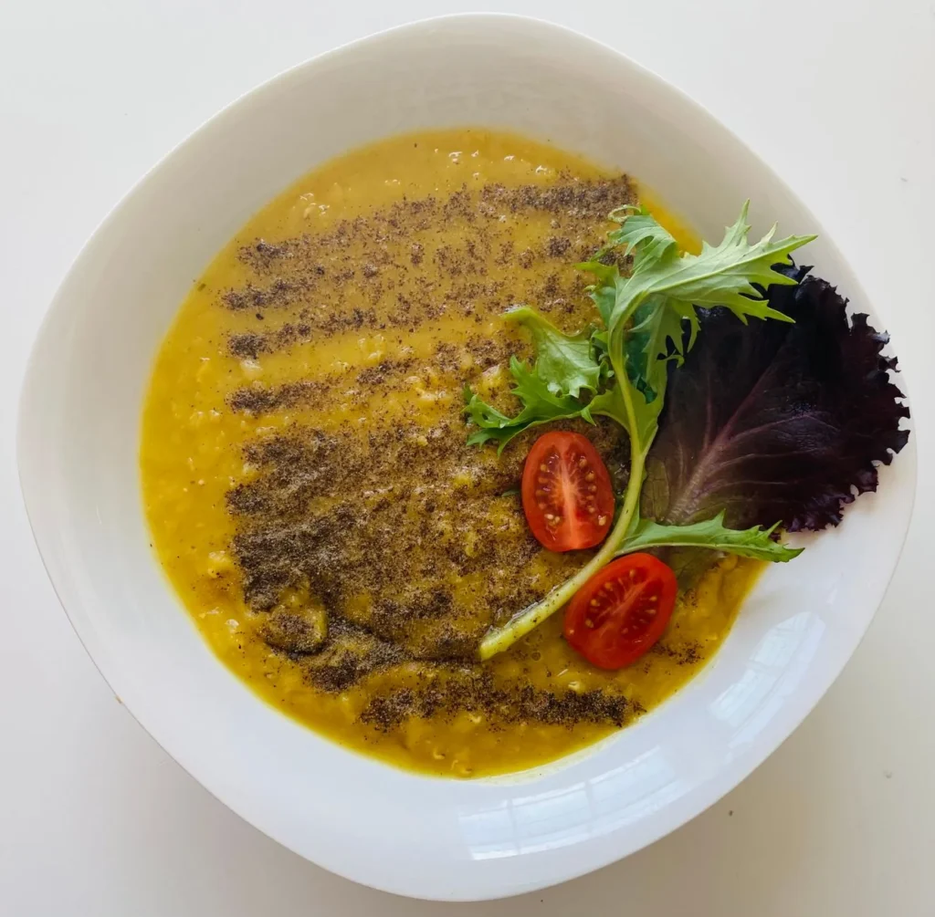 instant pot lentil soup recipe vegetarian in a white bowl with brown lentils, red lentils, carrots, and wilted spinach in clear broth